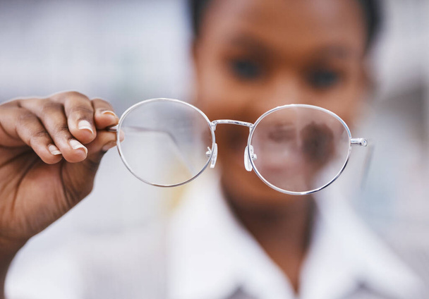 Vision, glasses in hand and woman in eye care clinic for health, wellness and poor sight exam with blur. Eyesight, girl holding designer brand frame and lens in hands, healthcare and test for eyes - Fotografie, Obrázek