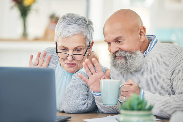 Ordenador portátil, pareja de ancianos y ola en videollamada con café en casa, hablando y hablando en casa. Ordenador, jubilación y hombre y mujer saludando en el chat virtual, saludo en línea y feliz. - Foto, Imagen