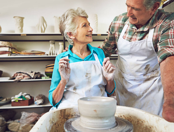 Їхня любов до глини зблизила їх. старша пара робить керамічний горщик разом у майстерні
 - Фото, зображення