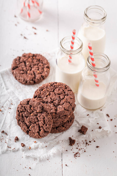 Homemade brown cookies made with chocolate and nuts. Chocolate cookies with milk. - Foto, afbeelding