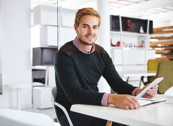 Los negocios son fáciles. Retrato recortado de un joven empresario usando una tableta digital en su escritorio en la oficina - Foto, imagen