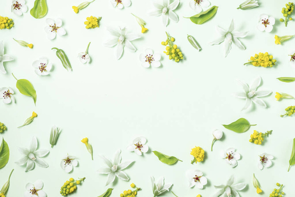 Virágkeret tavaszi virágok egy fehér háttér. Lapos fekvés, felülnézet, másolás. Gyönyörű virágminta pasztell színekben.  - Fotó, kép