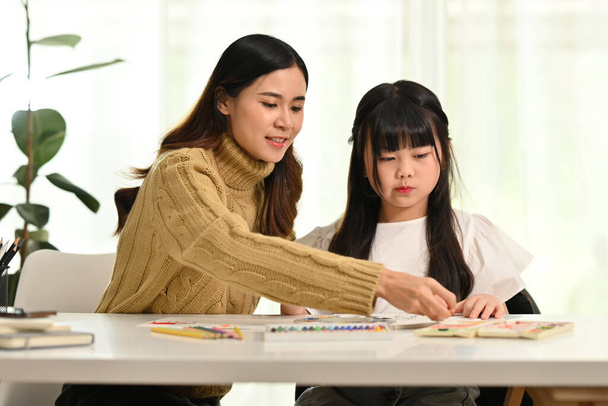 Küçük kızıyla resim çizen Asyalı bir anne. Aile evi eğlence konsepti. - Fotoğraf, Görsel