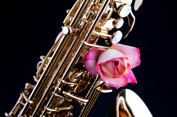 goldenes Messingsaxophon und rosa Rose - Foto, Bild