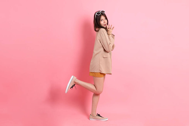 The young adult Asian woman with casual clothes on the pink background. - Фото, зображення