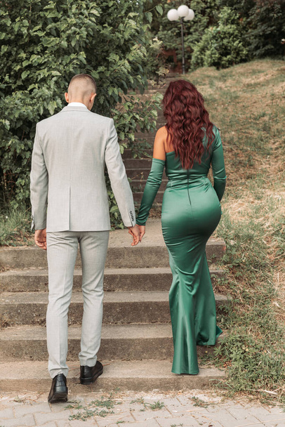 Young teenage couple dressed up for the prom, walking together. Back view - Foto, Bild