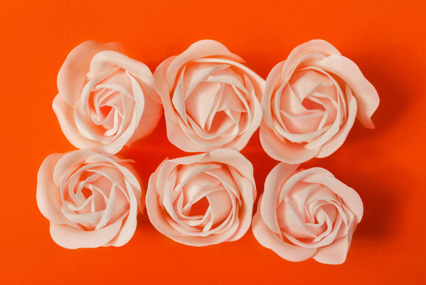 Six roses de savon sur fond orange vif, vue de dessus. Le concept de soin de la peau, beauté, Saint Valentin. - Photo, image