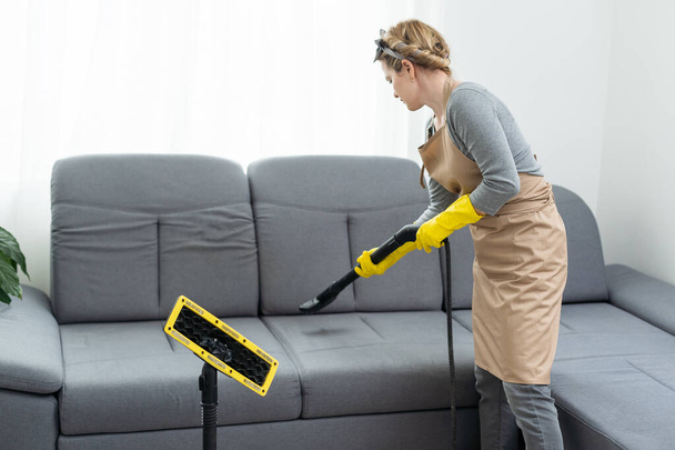 Сотрудник химчистки убирает грязь с мебели в квартире, крупным планом
 - Фото, изображение