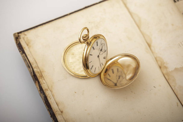 vintage zlaté kapesní hodinky dlouhé izolované na bílém pozadí, kapesní hodinky na pozadí knihy - Fotografie, Obrázek