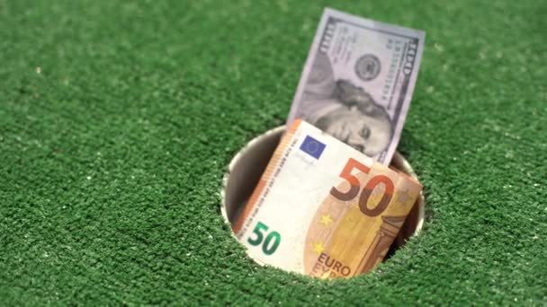 Montón de dinero en el agujero del campo de golf - Concepto de tiro de dinero - Metraje, vídeo