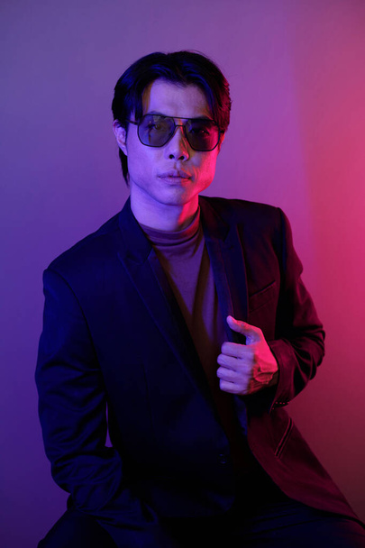 Portrait of serious confident man in black jacket and sunglasses looking at camera - 写真・画像