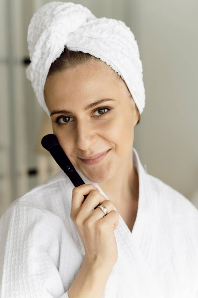 sexy girl takes care of her face holding a brush in her hands. face care. dermatology. healthy lifestyle - Foto, immagini