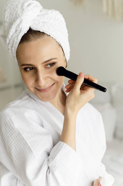 sexy girl takes care of her face holding a brush in her hands. face care. dermatology. healthy lifestyle - Φωτογραφία, εικόνα