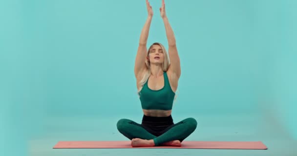 Fitness, donna e mediazione yoga in studio su tappetino per allenamento o esercizio su sfondo blu. Ritratto di yogi donna felice che medita per il benessere spirituale sul pavimento per esercitarsi sul mockup. - Filmati, video