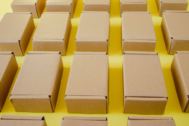 Many cardboard kraft boxes on a yellow background. Packing the parcel - Foto, Imagem