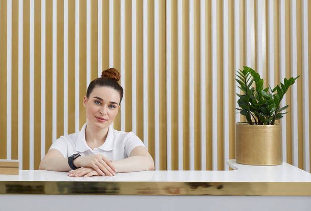 Female receptionist at reception desk in modern office lobby - Photo, Image