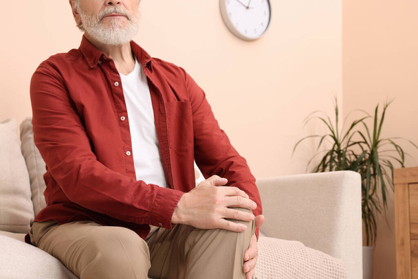 Senior man suffering from pain in his knee at home, closeup. Arthritis symptoms - Φωτογραφία, εικόνα