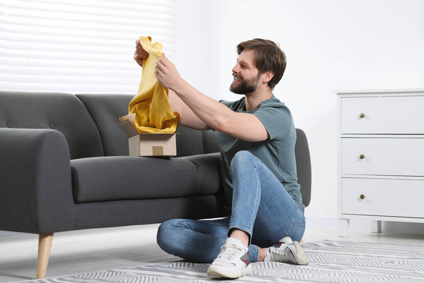 Happy man with parcel at home. Internet shopping - 写真・画像