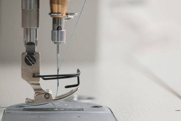 Modern sewing machine on blurred background, closeup. Space for text - Zdjęcie, obraz