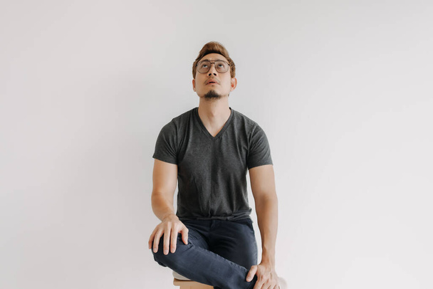 fresco asiático hombre gangster estilo sentado en negro camiseta aislado en blanco. - Foto, Imagen