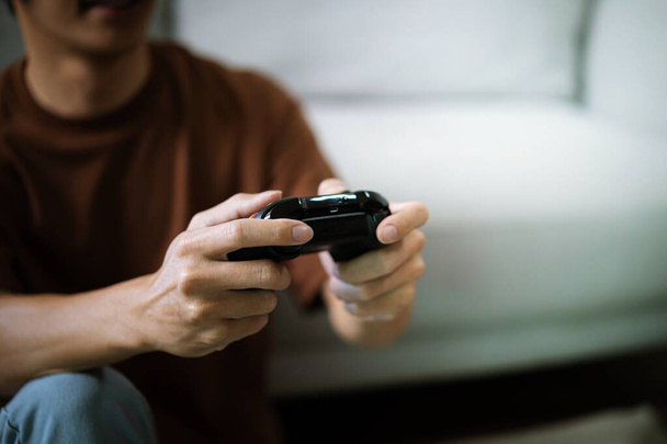 Young Asian man gamer controller video console playing holding hobby playful Online Video Game enjoyment eSport Cyber Games Internet - Φωτογραφία, εικόνα