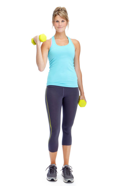 Getting a great workout. Attractive young woman in sportswear lifting dumbbells while isolated on white - Foto, imagen