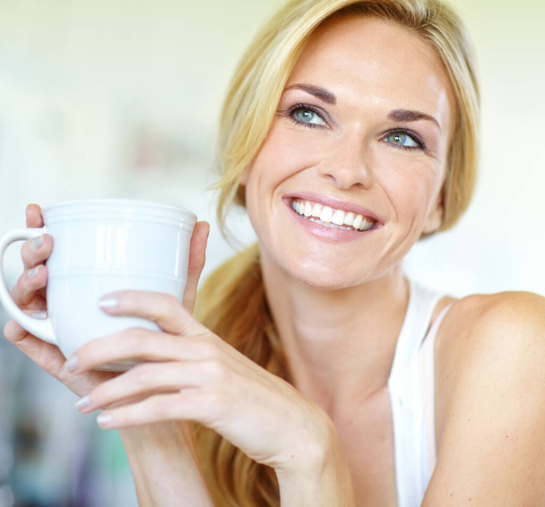 Great coffee and a brilliant smile. Attractive young blonde woman enjoying a delicious freshly-brewed cup of coffee - Foto, immagini
