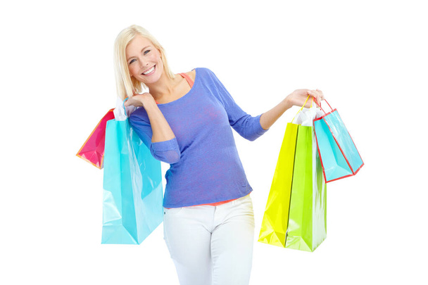 I just bought some really amazing clothes. An excited young woman holding shopping bags while isolated on a white background - Foto, Imagen