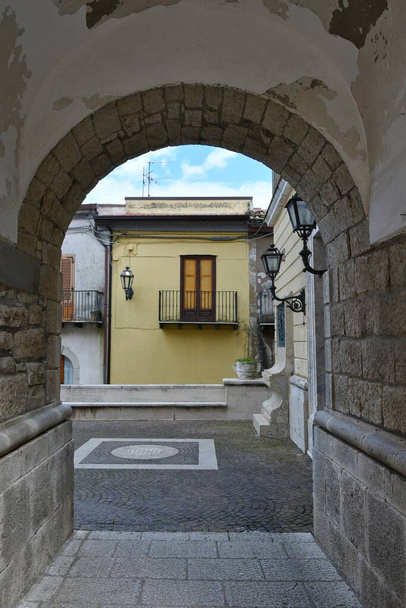 Узкая улочка среди старых домов Сан-Лупо, маленького городка провинции Беневенто, Италия. - Фото, изображение