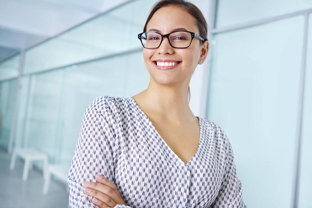 This office take jobs satisfaction up a notch. Portrait of an attractive young woman standing in an office - Photo, image