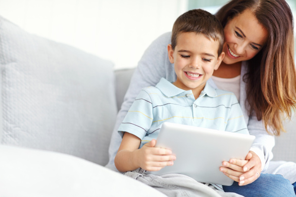 I need moms help. A mother helping her son use a digital tablet - Foto, imagen