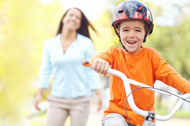 Aldın bile. Bekar bir anne oğlunun ilk kez bisiklet sürüşünü izliyor. - Fotoğraf, Görsel