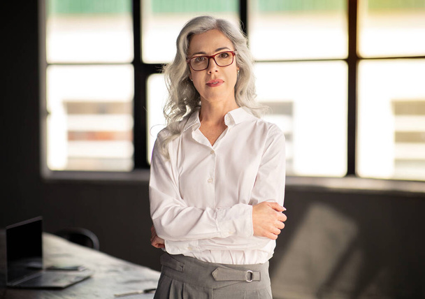 Successful Businesswoman. Confident Business Lady Smiling At Camera Standing Crossing Hands In Modern Office, Wearing Eyeglasses. Shot Of Successful Female Employee. Employment Concept - Foto, Bild