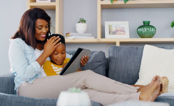 Birlikte en sevdiğimiz dizileri izliyoruz. Genç bir anne ve sevimli oğlunun dijital tablet kullanırken çekilmiş uzun bir fotoğrafı. - Fotoğraf, Görsel