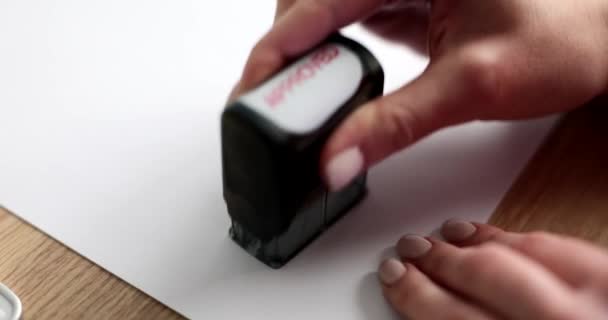 Kobieta na pustym papierze umieszcza zatwierdzoną pieczęć, a jej ręce są bliskie. Zgoda, pozytywna odpowiedź - Materiał filmowy, wideo