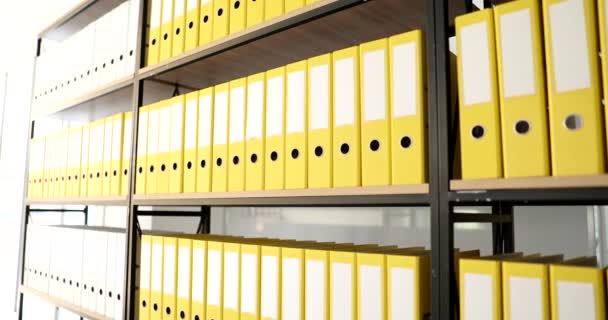 Yellow folders on a big book rack in the office, close-up. The archive has many from ring binders, slowmotion - Footage, Video