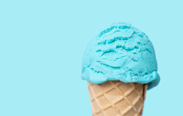 Blue ice cream scoop in cone, bright blue background - Fotoğraf, Görsel
