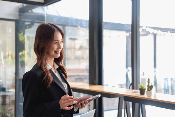 Marketing, Financial, Accounting, Planning, bAsian female entrepreneur in hand holding a smart phone Expressing joy that the company has succeeded in gaining profits from business management. - 写真・画像