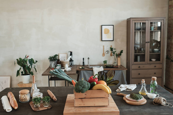 Modern kitchen in minimalistic style furnished with old-fashioned cabinet and tables with healthy food and kitchen utensils - Fotografie, Obrázek