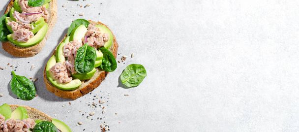 Тосты из тунца авокадо, здоровый перекус или завтрак на светлом бетонном фоне - Фото, изображение