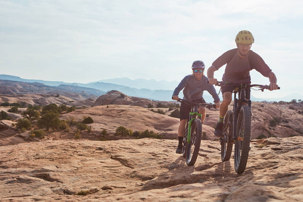 Vivere la natura in bicicletta. Colpo completo di due uomini atletici mountain bike attraverso la natura selvaggia - Foto, immagini