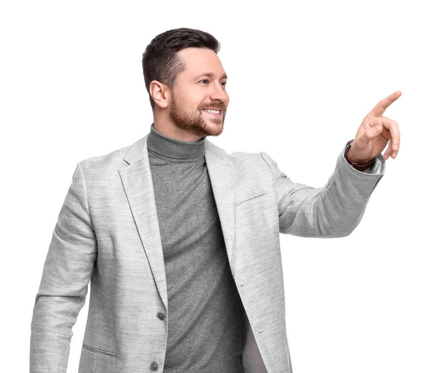 Handsome bearded businessman in suit pointing at something on white background - Photo, Image