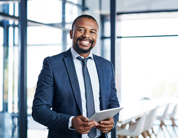 Business is so good when youre connected. Cropped portrait of a handsome middle aged businessman smiling while holding a digital tablet in a modern office - Fotó, kép