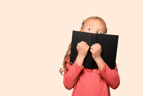 Little girl with book on light background. Space for text - Photo, image