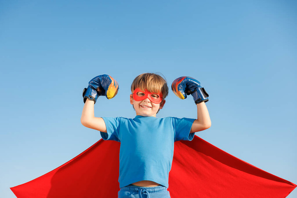 Superhero child against summer blue sky. Super hero boy having fun outddor. Healthy lifestyle concept - Fotoğraf, Görsel