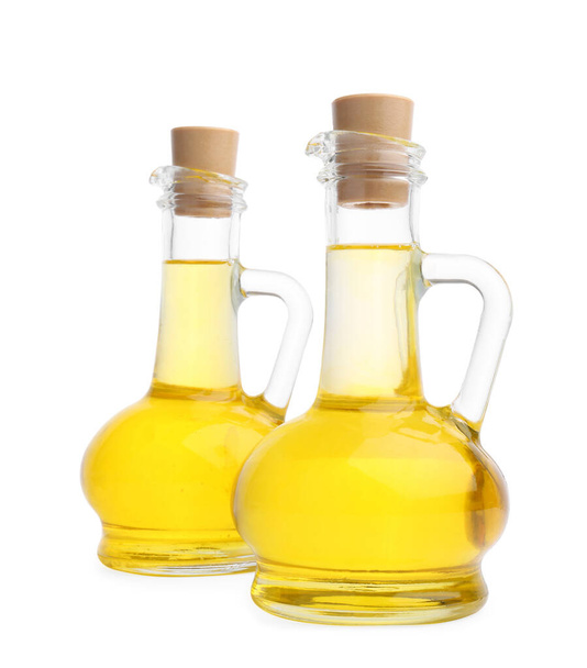 Glass jugs of cooking oil on white background - Fotó, kép