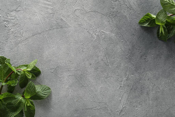 Food photography. Fresh aromatic mint leaves on grey textured table, flat lay with space for text - Φωτογραφία, εικόνα