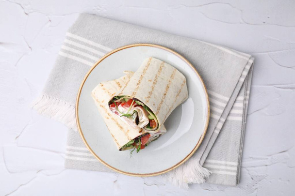 Delicious sandwich wraps with fresh vegetables on white textured table, top view - Foto, Imagem