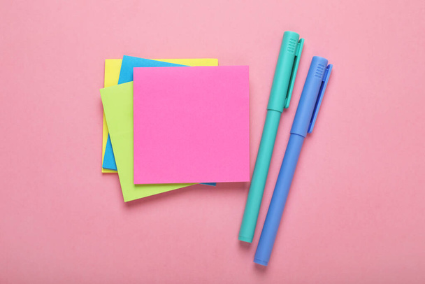 Paper notes and colorful markers on pink background, flat lay - Foto, Imagem