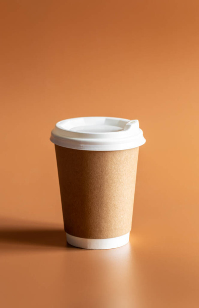 廃棄物ゼロライフスタイル、クラフト使い捨てブラウンカップ白いプラスチック製の蓋茶色の背景に孤立. - 写真・画像